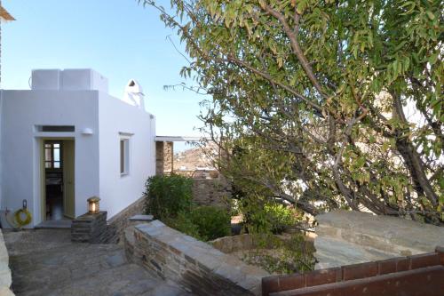 a white house with a tree in front of it at Cycladic Fos - Entire SeaView 2BR Villa by TinosHost in Triandáros