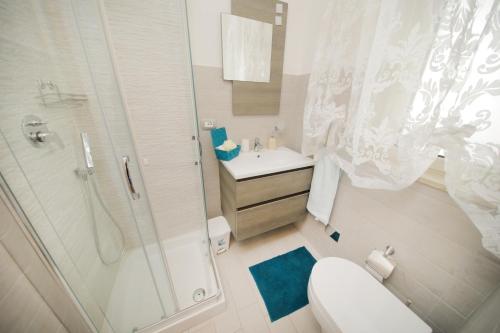 een badkamer met een douche, een toilet en een wastafel bij Io, te e il mare in Polignano a Mare