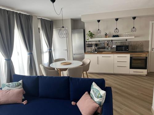 a living room with a blue couch and a kitchen at Casa Aguamarina in Corralejo