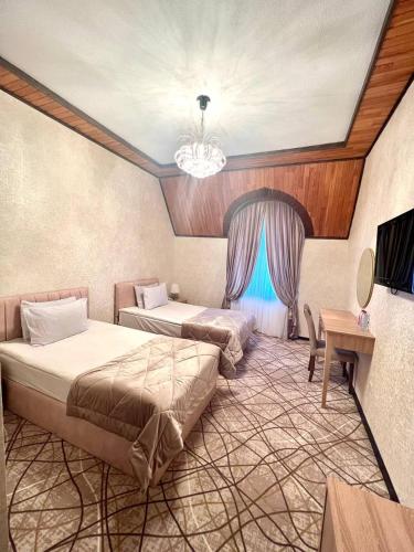 a bedroom with two beds and a chandelier at Cinema Boutique Hotel in Ganja