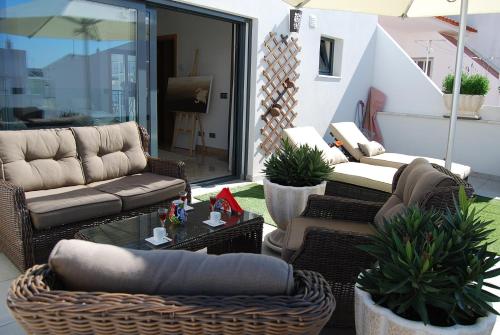 a patio with couches and chairs and a table at The Birds Nest in Alvor
