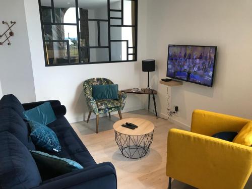 佩羅斯－吉雷克的住宿－Joli appartement très bien situé - Perros-Guirec，客厅配有蓝色的沙发和两把椅子