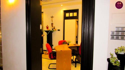a room with a table and chairs and a mirror at Airport Faith Hotel in Katunayake