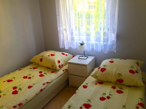 a bedroom with two beds and a window at DOMKI NA TURYSTYCZNEJ in Dąbki