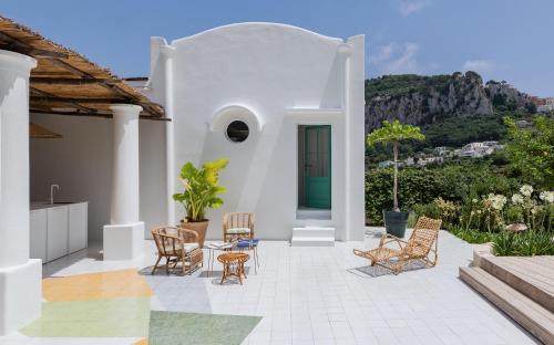 Casa blanca con sillas y mesa en Capri Suite Marina Grande, en Capri