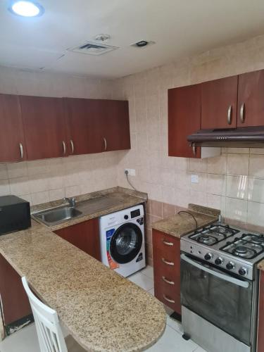 a kitchen with a stove and a counter top at Almond Tower A5 in Ajman 