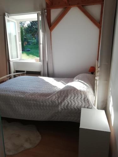 une chambre avec un lit et une fenêtre dans l'établissement Gîte de caractère, à Thauron