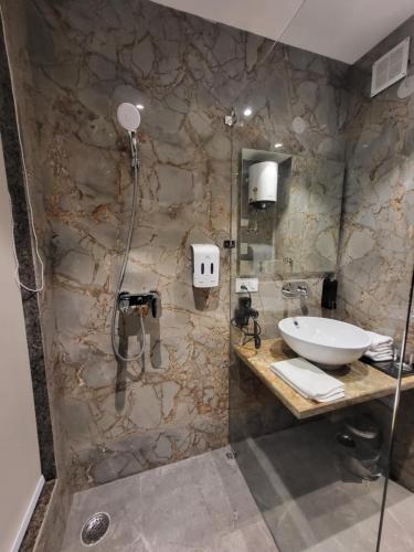 a bathroom with a sink and a shower at Belvedere Suites in Greater Noida