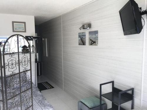 Cette chambre est dotée d'un mur et d'une télévision. dans l'établissement Résidence Port Nature Colline 2 - Studio 2 pers - Port Nature Colline 2 MAE-6154, au Cap d'Agde