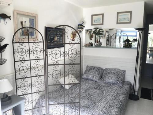 - une chambre avec un lit et un portail en fer forgé dans l'établissement Résidence Port Nature Colline 2 - Studio 2 pers - Port Nature Colline 2 MAE-6154, au Cap d'Agde