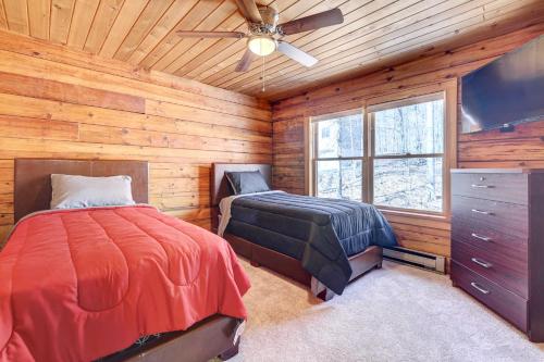 a bedroom with two beds and a flat screen tv at Pocono Vacation Rental with Game Room! in Tobyhanna