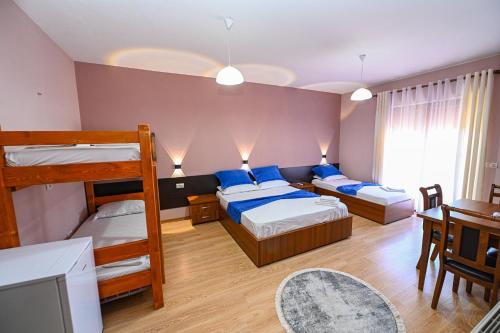 sypialnia z 2 łóżkami piętrowymi i stołem w obiekcie Hotel Epoka w Szkodrze