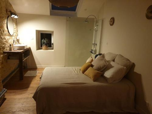 - une chambre avec un lit et des oreillers dans l'établissement Logement Cosy 2 à 4 Personnes Campagne proche Mer, à Frossay