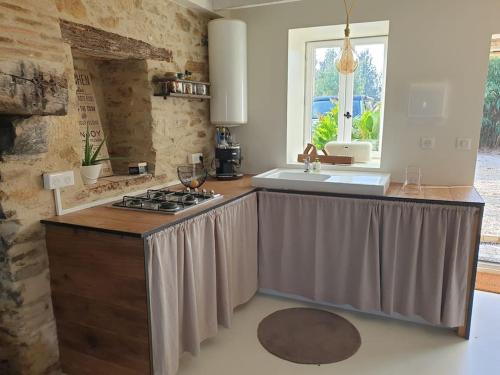 a kitchen with a sink and a stove top oven at Logement Cosy 2 à 4 Personnes Campagne proche Mer in Frossay