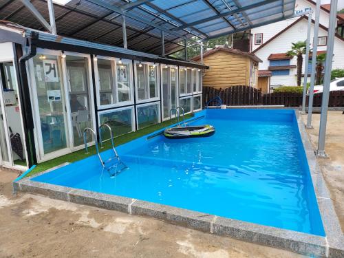 une maison avec une piscine en face d'une maison dans l'établissement oneday in geoje, à Geoje
