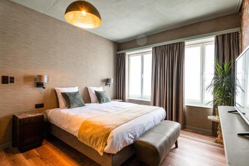 a bedroom with a large bed in a room with windows at Boutique hotel Sies in Watervliet