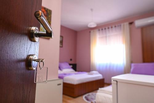 a room with a door with a room with two beds at Hotel Epoka in Shkodër