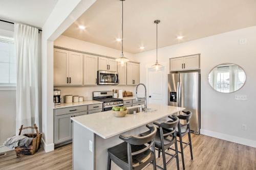 a kitchen with white cabinets and a large island with bar stools at Cozy Montana Retreat with Patio Near Parks! in Billings