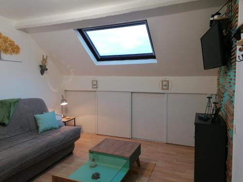 uma sala de estar com um sofá e uma clarabóia em Studio a 5 km de Berck-sur-Mer em Waben