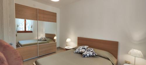 カステッラネータ・マリーナにあるCollins Apartmentsのベッドルーム1室(ベッド2台、鏡付)