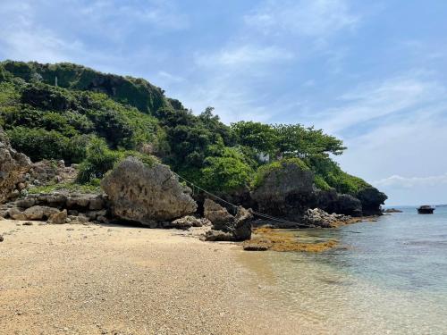 a rope bridge on a beach near the ocean at Premium Villa Miyagi Island in Ikei