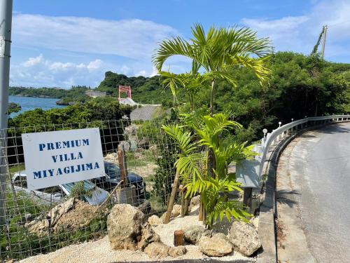 a sign on the side of a road with palm trees at Premium Villa Miyagi Island in Ikei