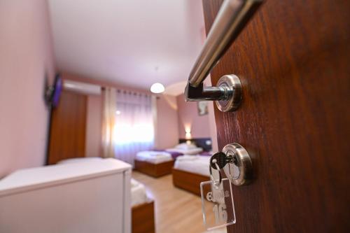 a room with a door and a room with two beds at Hotel Epoka in Shkodër