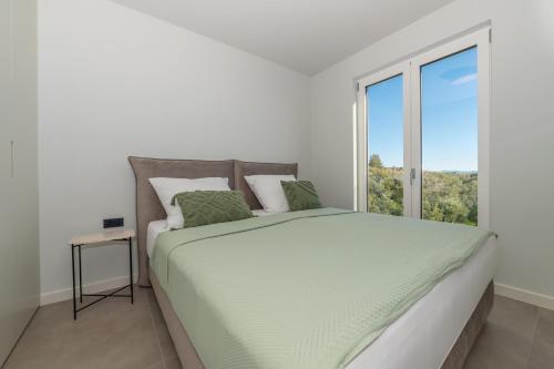 a white bedroom with a large bed with a window at Apartment Adriatic Pearl -NEW 2023- in Tučepi