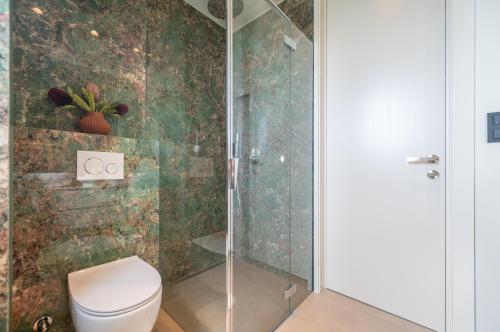 a bathroom with a toilet and a glass shower at Apartment Adriatic Pearl -NEW 2023- in Tučepi