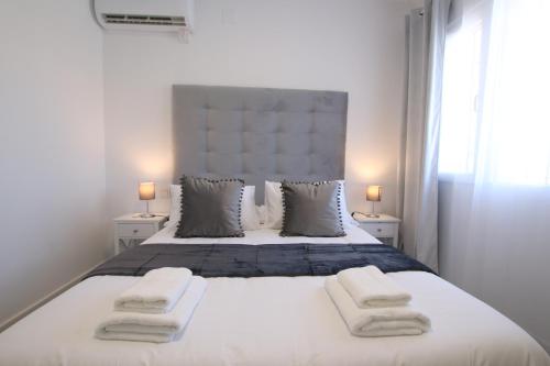 a bedroom with a large white bed with towels on it at TESS Villa Paz in Alhaurín de la Torre