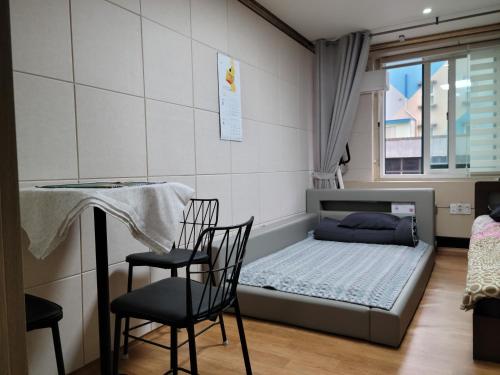 a room with a bed and two chairs and a table at Canberra Town 439-3 in Changwon