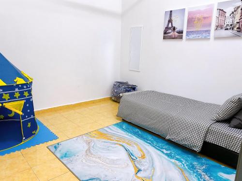 um quarto com uma cama e um tapete no chão em Mirahani Homestay Melaka em Malaca