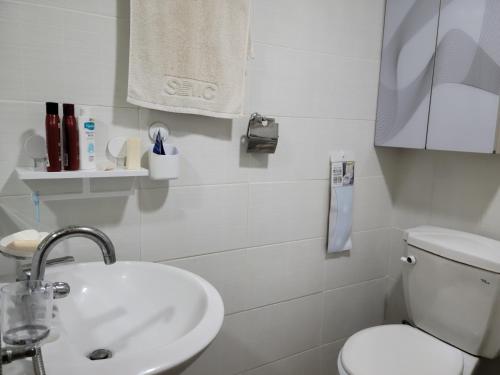 La salle de bains blanche est pourvue de toilettes et d'un lavabo. dans l'établissement Canberra Town 439-3, à Changwon