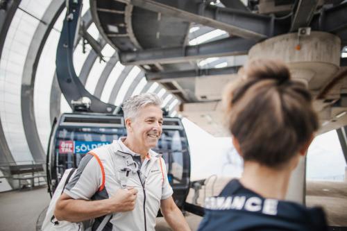 a man talking to a woman in a bus at Apart Ida in Sölden