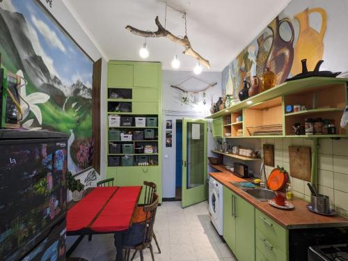a kitchen with green cabinets and a table in it at Namaste Hostel in Tbilisi City