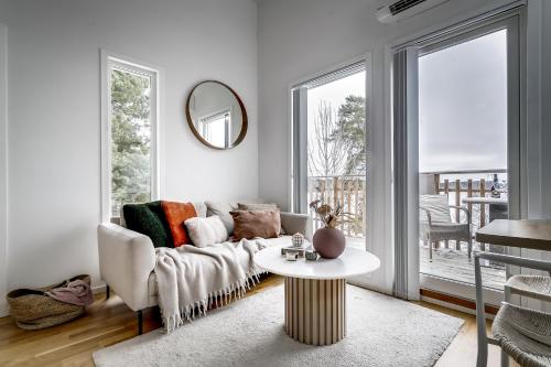 uma sala de estar com um sofá e uma mesa em Relaxing Lake Oasis with Jacuzzi - Amazing view & Private Pier em Estocolmo