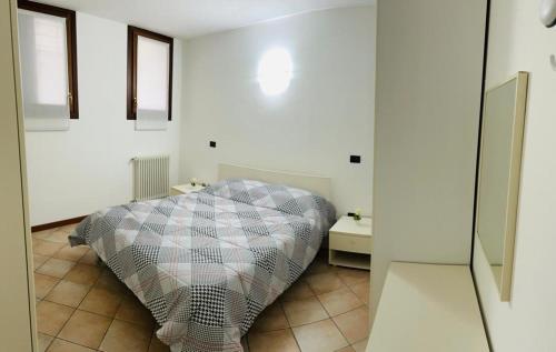 1 dormitorio con 1 cama en una habitación blanca en Appartamento centro storico Conegliano, en Conegliano
