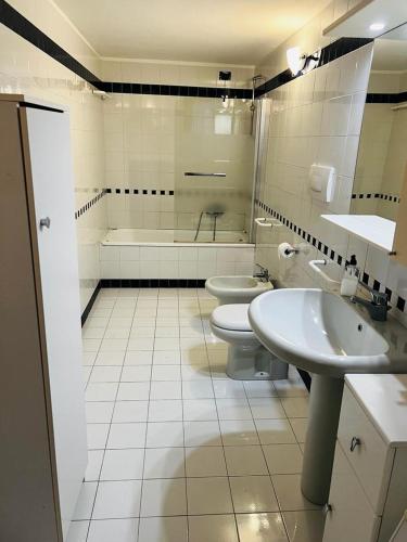 a bathroom with two sinks and a toilet and a tub at Appartamento centro storico Conegliano in Conegliano