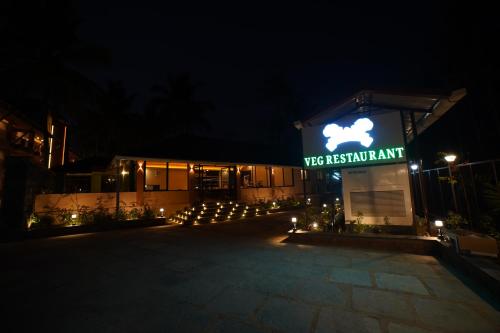 a building with a sign that reads vet restraintant at night at Aananda Wellness and Resorts in Dharmastala