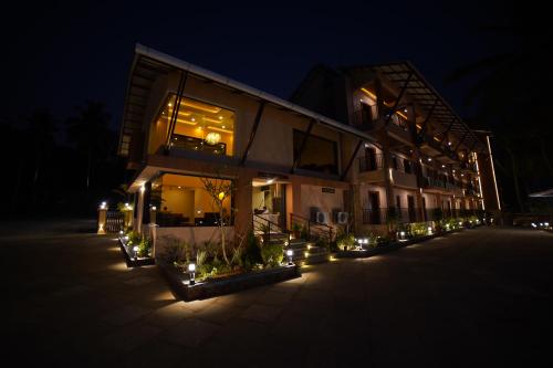 a building with lights in front of it at night at Aananda Wellness and Resorts in Dharmastala