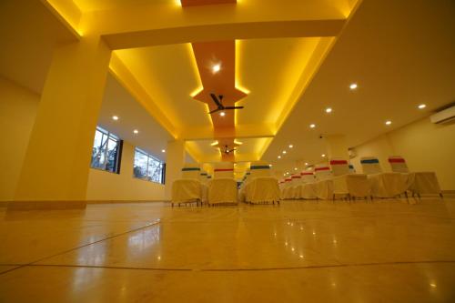 a large room with chairs and tables in it at Aananda Wellness and Resorts in Dharmastala