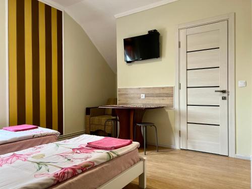 a bedroom with two beds and a tv on the wall at Юкон in Konopnitsa