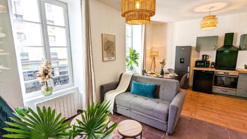 un salon avec un canapé et une chaise dans l'établissement Cosy Calypso 2CH - Quartier des Halles & parking, à Pau