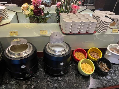 a counter with two crock pots and bowls of food at Taichung Charming City Hotel in Taichung