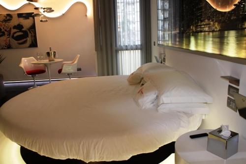 a bedroom with a large white bed and a table at DOMUS Grand Hotel in Rende