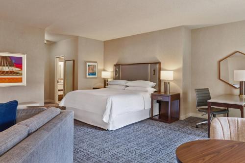 a hotel room with a large bed and a couch at Sheraton Music City Nashville Airport in Nashville
