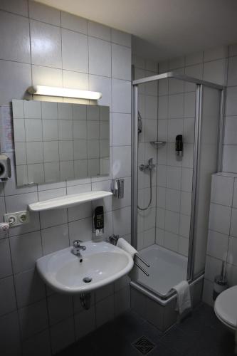 a bathroom with a shower and a sink and a shower at Avenue Hotel in Nürnberg