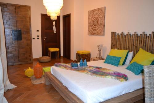um quarto com uma cama grande e almofadas coloridas em Villa Ethnic Chic em Bisceglie