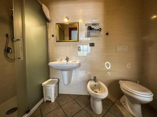 a bathroom with a sink and a toilet and a urinal at B&B Il Leccio in Alberobello