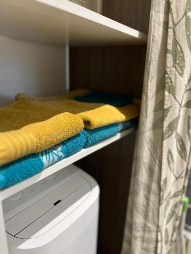 a shelf with towels and a bed in a room at maison entre Disneyland et Paris in Meaux